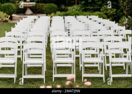 Le gros plan des rangées de chaises sur la pelouse à l'extérieur pour une cérémonie de mariage Banque D'Images