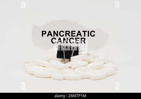Concept médical. Sur une surface blanche sont les pilules et le papier déchiré avec l'inscription - cancer pancréatique Banque D'Images