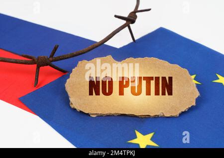 Concept politique. Sur les drapeaux de l'Union européenne et de la Russie se trouve une plaque de carton avec l'inscription - pas de Poutine. Drapeaux séparés par un barbelé Banque D'Images