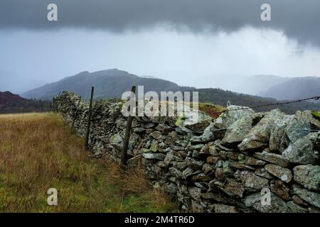 Mur de pierre sèche sur Black Fell, Tilberthwaite Fells en arrière-plan. Banque D'Images