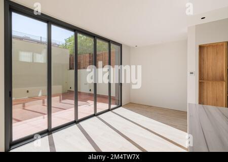 Ombres sur le sol de la lumière du soleil par de grandes fenêtres. Cette nouvelle chambre dispose de parquet et d''un patio dans un appartement rénové. Banque D'Images