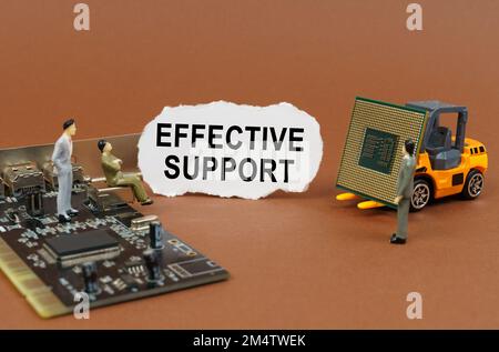 Concept de technologie et d'entreprise. Sur une surface marron, un chargeur avec un processeur, un microcircuit, des figures de personnes et du papier déchiré avec l'inscription Banque D'Images