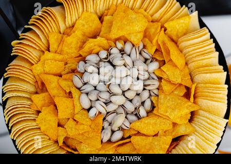 Chips et pistaches sur une assiette, un apéritif pour la bière. Banque D'Images