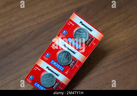 Quelques piles bouton Panasonic CR2032 3V scellées sur fond de bois. Banque D'Images