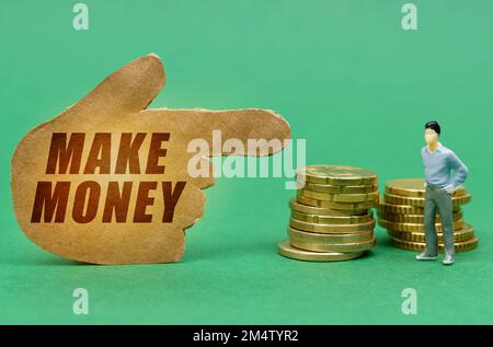 Concept d'affaires et d'économie. Sur la surface verte de la pièce et la figure d'un homme, ils sont indiqués par un signe - une main avec l'inscription - MAK Banque D'Images