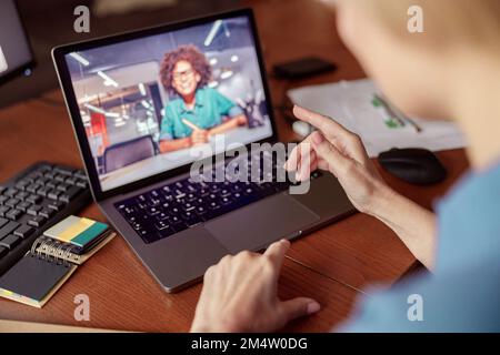 Une femme méconnaissable parle avec un client par appel vidéo en ligne depuis son bureau à domicile Banque D'Images