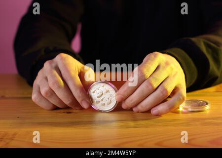 monnaie chinoise argent 10 yuan panda dans les mains sur la table et fond coloré Banque D'Images