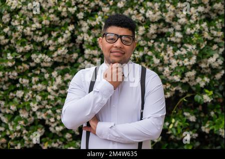 Jeune homme debout devant les plantes Banque D'Images