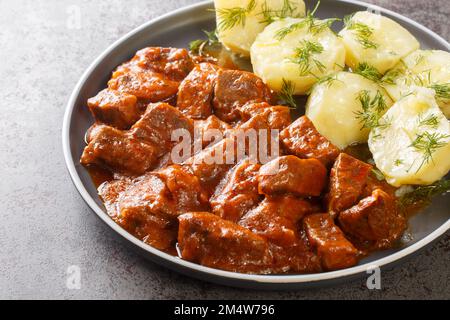 Le saftgulasch de Wiener est un ragoût copieux qui se compose de morceaux de bœuf maigre trempés dans une épaisse sauce savoureuse sur l'assiette de la table. Horizonta Banque D'Images