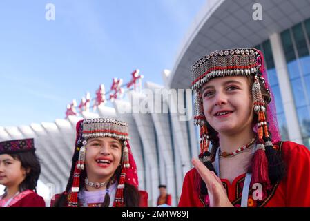 (221223) -- TAXKORGAN, 23 décembre 2022 (Xinhua) -- les filles tadjikes en tenue traditionnelle accueillent les passagers du premier vol à l'aéroport de Taxkorgan, dans le comté autonome de Tajik, dans la région autonome de Xinjiang Uygur, dans le nord-ouest de la Chine, le 23 décembre 2022. Vendredi matin, un avion passager est arrivé dans le comté autonome du Tajik, dans la région autonome du Xinjiang au nord-ouest de la Chine, marquant l'inauguration du premier aéroport de la région à plateau élevé. Au départ de la capitale régionale Urumqi à 8 h 57, le vol CZ5193, exploité par China Southern Airlines, a atterri à l'aéroport de Taxkorgan Banque D'Images