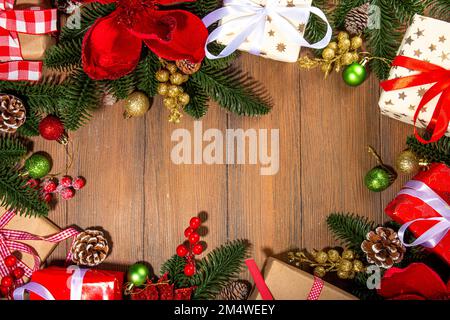 Noël traditionnel, vacances du nouvel an arrière-plan avec branches d'arbre de Noël, baies rouges d'hiver, fleurs de poinsettia, boîtes-cadeaux, sur le dos en bois Banque D'Images