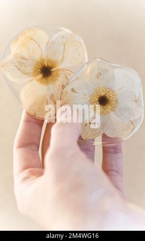 Gros plan main femelle montrant des fleurs sèches en résine époxyde concept photo Banque D'Images