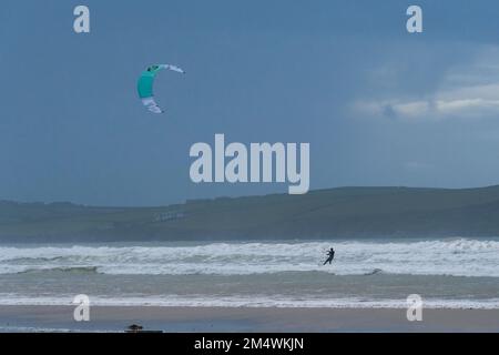 Polzeath, Cornwall, Royaume-Uni.23rd décembre 2022. Météo Royaume-Uni. C'était terne mais bien sur la plage de Polzeath cet après-midi. Avec kite surfeurs et randonneurs de chiens appréciant les conditions. Crédit Simon Maycock / Alamy Live News. Banque D'Images