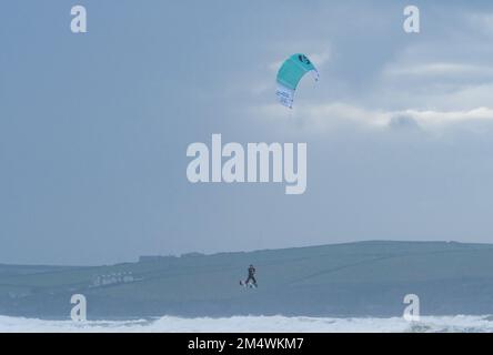 Polzeath, Cornwall, Royaume-Uni.23rd décembre 2022. Météo Royaume-Uni. C'était terne mais bien sur la plage de Polzeath cet après-midi. Avec kite surfeurs et randonneurs de chiens appréciant les conditions. Crédit Simon Maycock / Alamy Live News. Banque D'Images