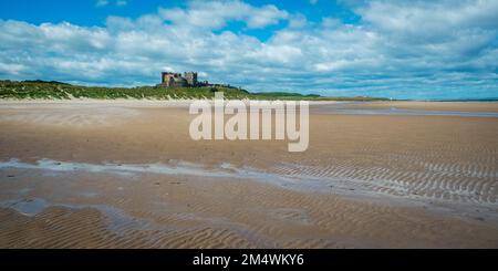 En regardant vers le nord-ouest jusqu'au château historique de Bamburgh à l'horizon au-dessus de la plage de Bamburgh, Northumberland, Royaume-Uni Banque D'Images