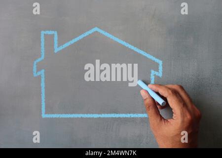 Vue de dessus de l'icône de maison de dessin sur tableau noir. Copier l'espace pour le texte Banque D'Images