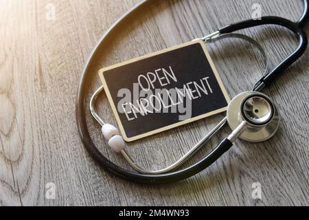 Stéthoscope et tableau noir avec inscription OUVERTE sur table en bois. Concept médical et de soins de santé Banque D'Images