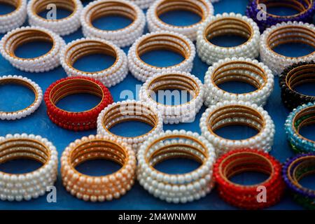 Dhaka, Bangladesh - 16 décembre 2022 : le belliciste de rue présente son collier de perles à vendre sur l'avenue Manik Mia à Dhaka, au Bangladesh. Banque D'Images