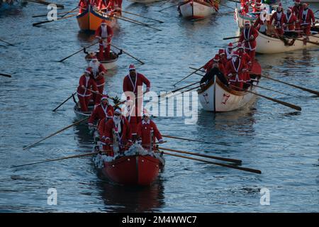 Des gens habillés comme le Père Noël lors d'une régate de Noël le long du Grand Canal à Venise, Italie, 18 décembre 2022. Banque D'Images