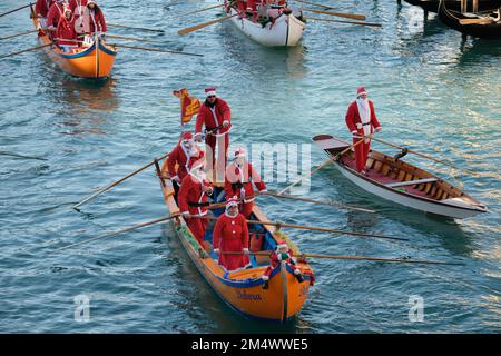 Des gens habillés comme le Père Noël lors d'une régate de Noël le long du Grand Canal à Venise, Italie, 18 décembre 2022. Banque D'Images