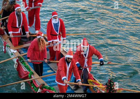 Des gens habillés comme le Père Noël lors d'une régate de Noël le long du Grand Canal à Venise, Italie, 18 décembre 2022. Banque D'Images