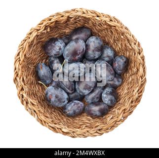 pruneaux dans un chemin de panier isolé sur la vue de dessus blanche Banque D'Images