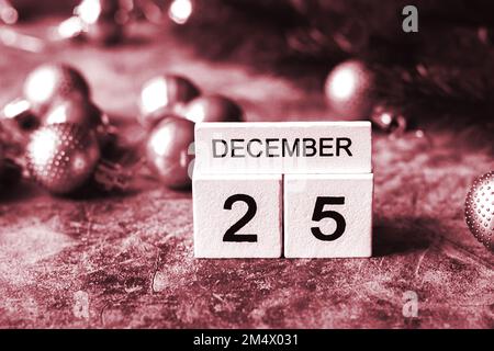 Date 25 décembre sur calendrier vintage en bois. Arrière-plan de Noël de couleur rouge Banque D'Images