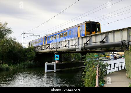 EMR train régional au-dessus de la rivière Great Ouse, ville d'Ely, Cambridgeshire, Angleterre Banque D'Images