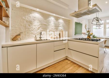 une cuisine avec parquet et armoires blanches au centre de la photo est une image d'un mur de pierre Banque D'Images