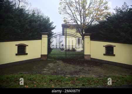 Porte d'un manoir avec haies lors d'une journée de brouillard dans la campagne italienne Banque D'Images