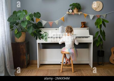 Jeune fille jouant du piano à la maison Banque D'Images