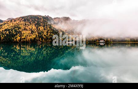 Magnifique vue sur le lac Anterselva avec le brouillard qui crée un environnement mystique et évocateur. couleurs d'automne dorées. Alto Adige, Italie Banque D'Images