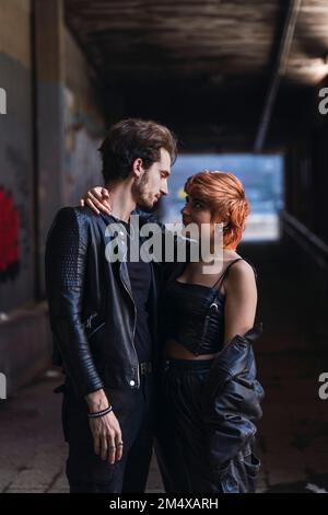 Jeune couple romantique debout ensemble dans le passage souterrain Banque D'Images