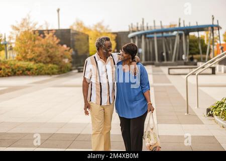 Homme âgé heureux avec le bras autour de la femme marchant sur le sentier Banque D'Images