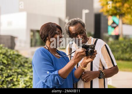 Couple heureux regardant la caméra debout dans le parc Banque D'Images