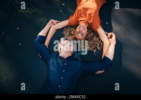 Homme et femme matures heureux couché sur trampoline Banque D'Images