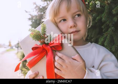 Une fille attentionnés tenant une boîte cadeau de Noël Banque D'Images