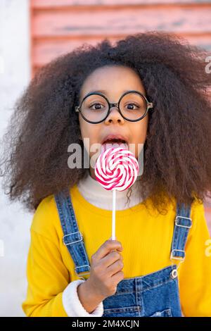 Jolie fille portant des lunettes de vue lévollipop Banque D'Images