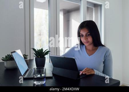 Jeune femme étudiant à la maison avec un ordinateur portable Banque D'Images
