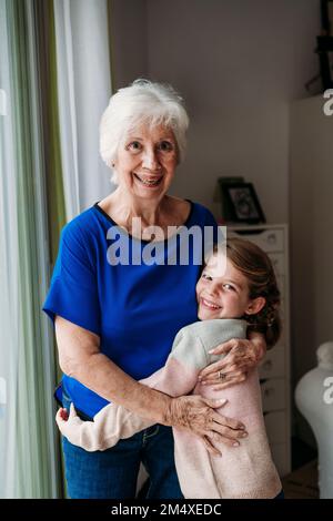 Bonne fille embrassant grand-mère à la maison Banque D'Images