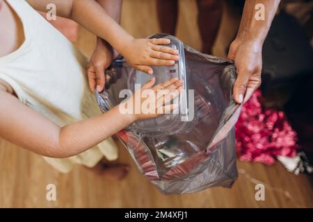 La mère et la fille ramassent les déchets en plastique dans la cuisine Banque D'Images