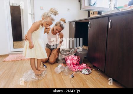 La mère et la fille ramassent les déchets en plastique dans la cuisine Banque D'Images