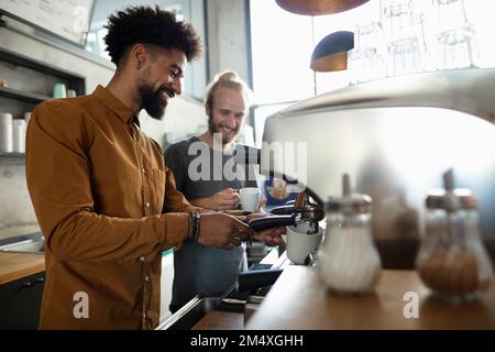 Les baristas sont heureux de préparer un café au café Banque D'Images