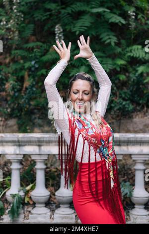 Danseur avec les bras levés faisant du flamenco devant la main courante Banque D'Images