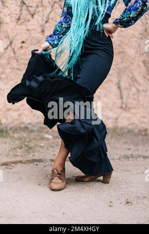 Danseur à la main sur la hanche faisant du flamenco devant le mur Banque D'Images