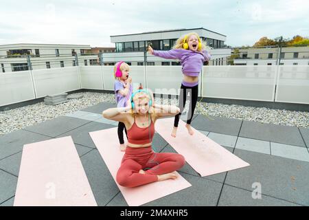 Mère et fille portant un casque pour s'amuser sur la terrasse Banque D'Images