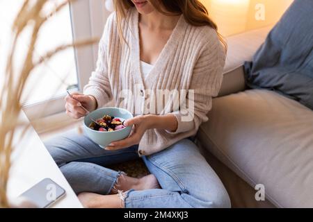 Jeune femme ayant le petit déjeuner à la maison Banque D'Images