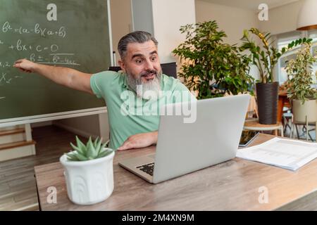 Professeur prenant des cours en ligne par appel vidéo sur ordinateur portable au bureau Banque D'Images