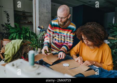 Les créateurs de mode travaillent ensemble sur le tissu denim en atelier Banque D'Images