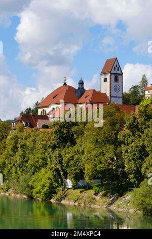 Allemagne, Bavière, Fussen, St. Abbaye de Mangs avec rive de la rivière Lech en premier plan Banque D'Images